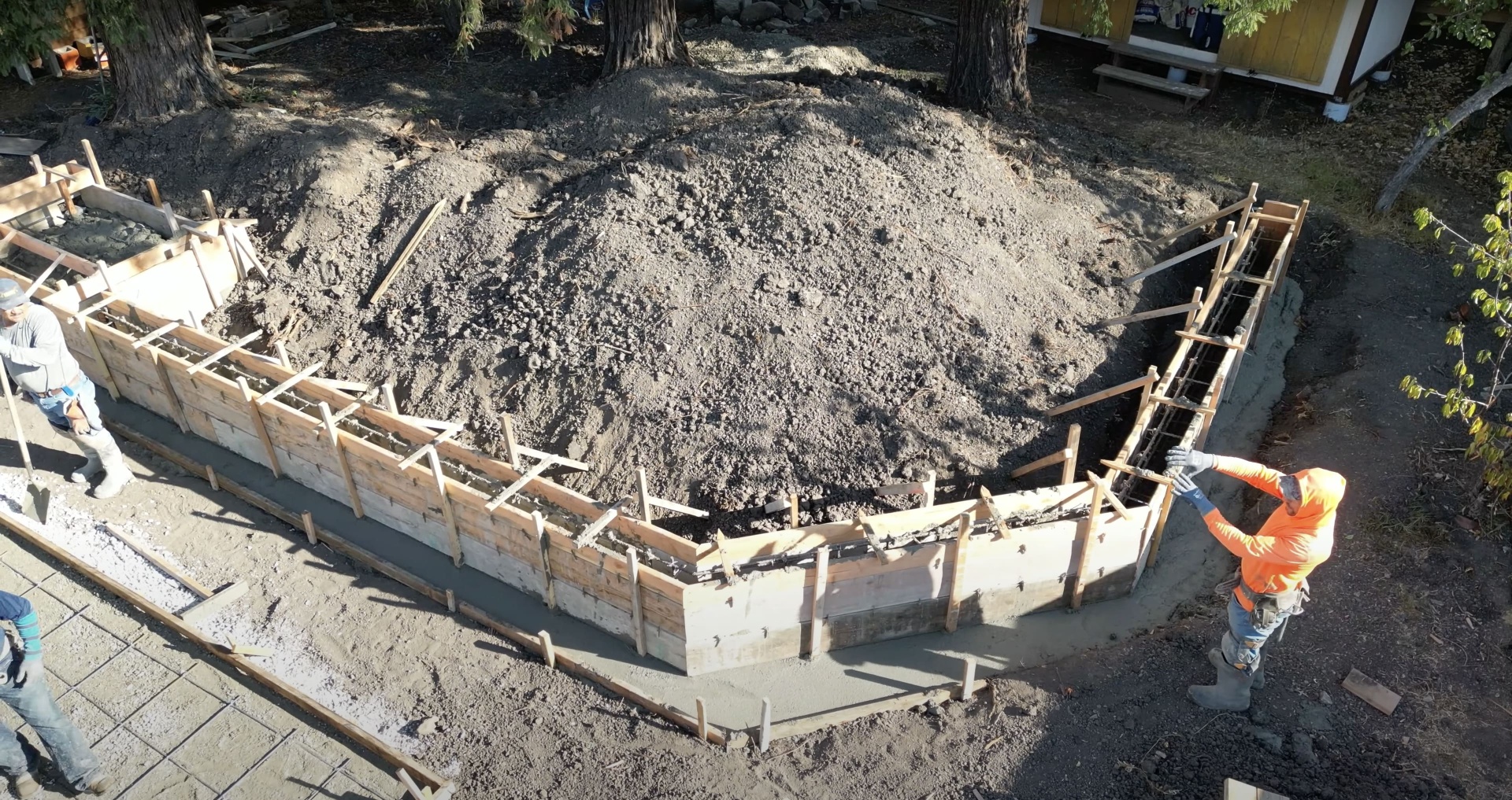 Professional foundation preparation with proper forming and excavation Foundation construction with wooden forms and excavation preparation