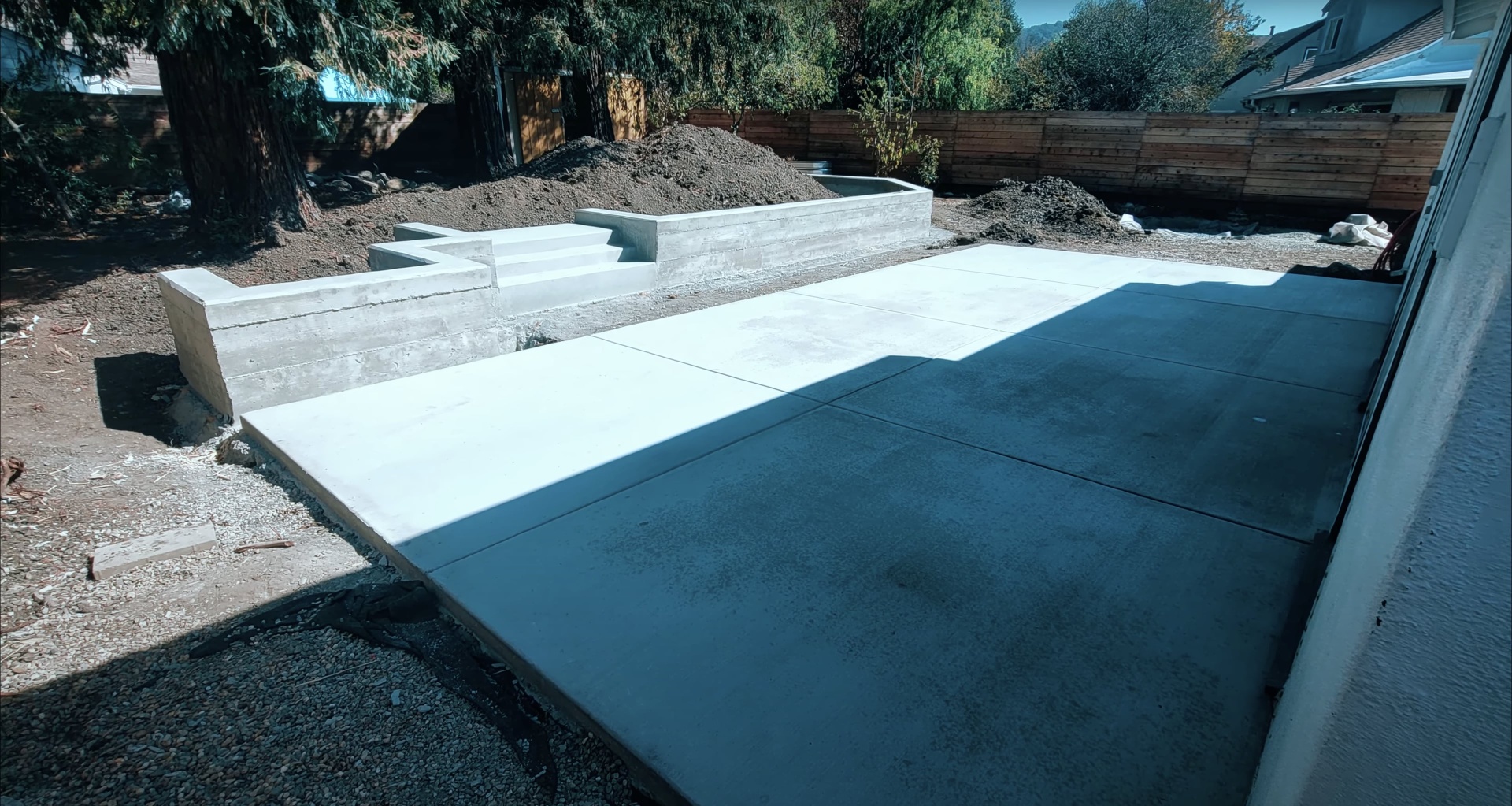 Contemporary concrete patio and retaining wall installation Modern concrete slab construction with retaining walls