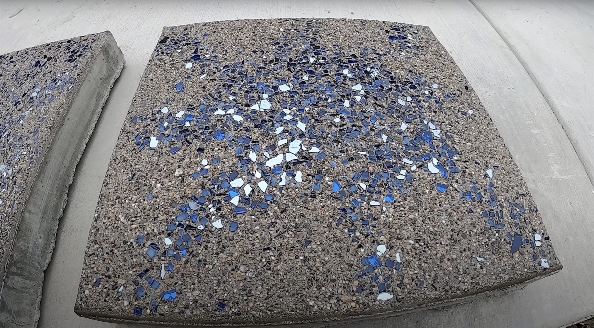 Custom decorative concrete with exposed aggregate and glass elements Decorative aggregate concrete with blue glass accents